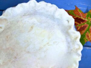 There is an unbaked pie crust in a pie plate.