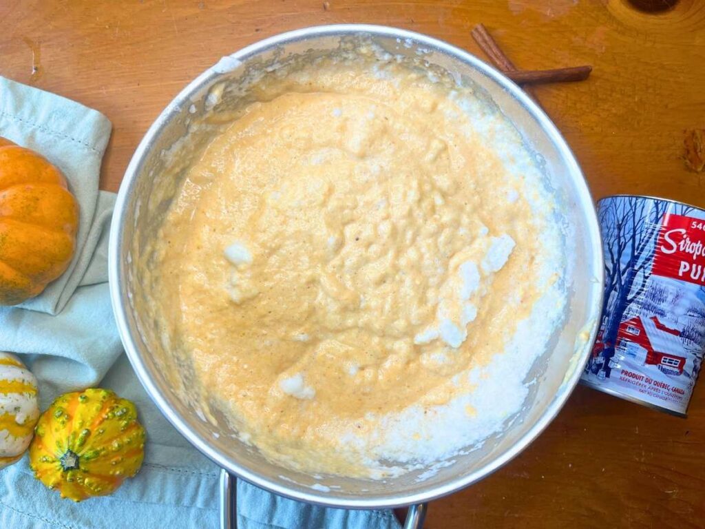 A metal bowl with pumpkin waffle batter inside.