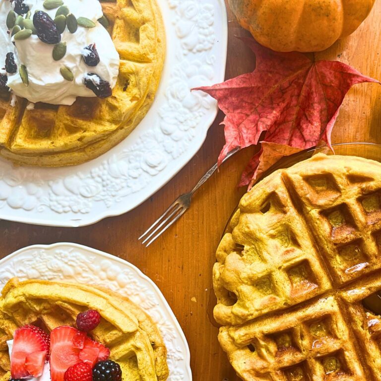 Three plates of pumpkin waffles all with different toppings.