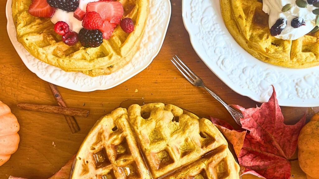 Three stacks of pumpkin waffles all with different toppings.