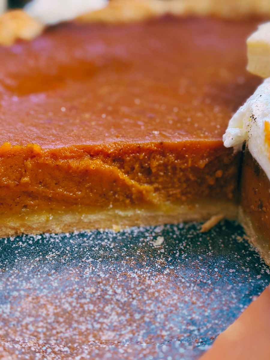 A side view of a sliced pumpkin pie.