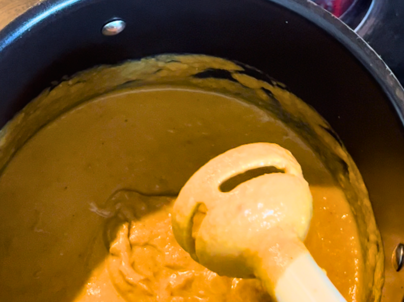 An emersion blender and a pot of butternut squash soup