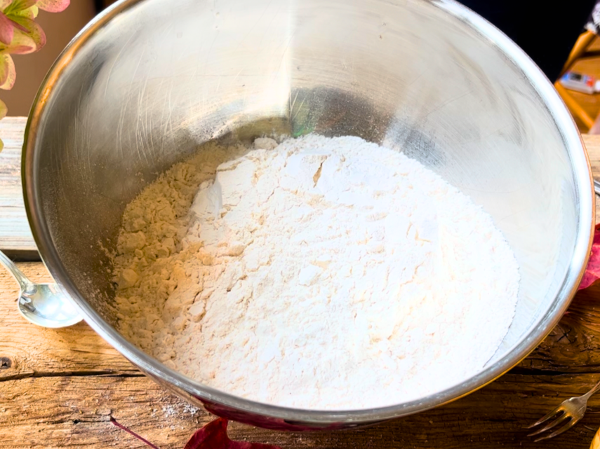 A metal bowl with all-purpose flour.