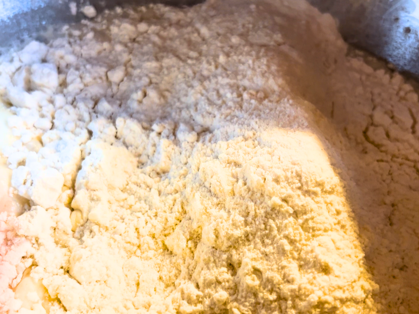 Flour being added to the bowl for pierogi dough