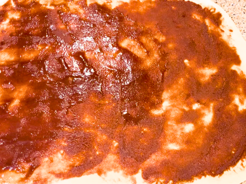 Cinnamon roll filling spread on top of a rectangle of dough