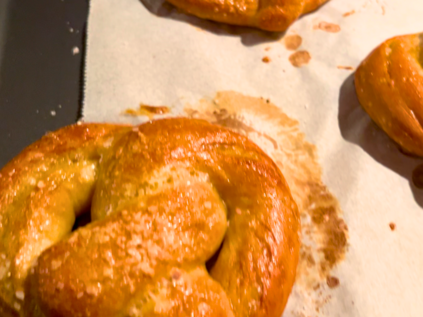 Baked pretzels on a cookie sheet with parchment paper