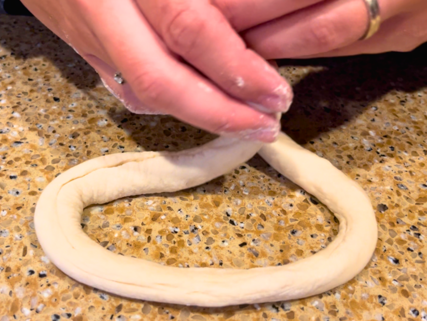 Woman shaping dough into a pretzel