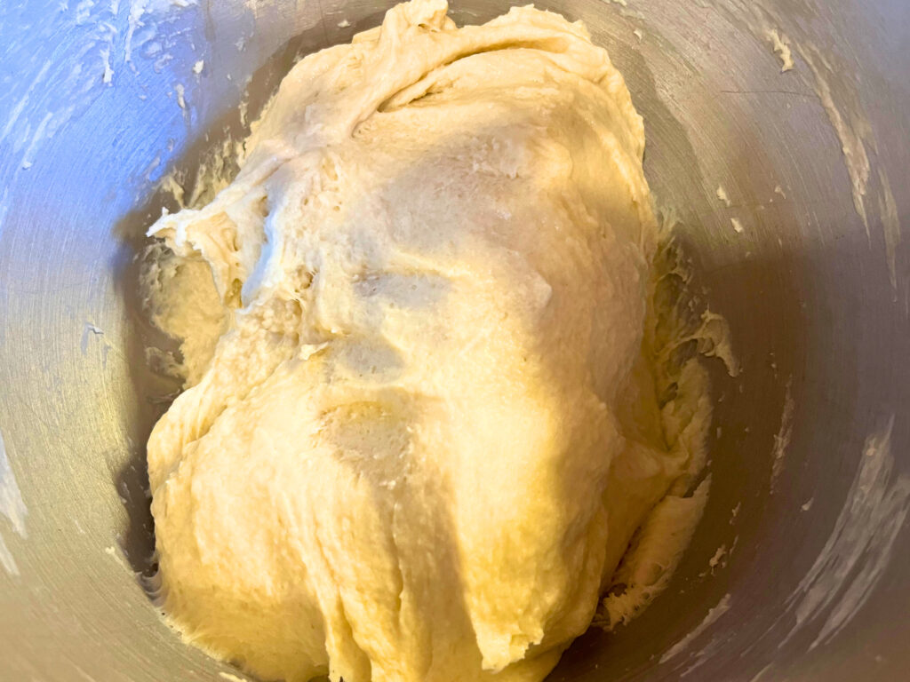 Pull apart dinner roll dough in the bowl of a stand mixer.