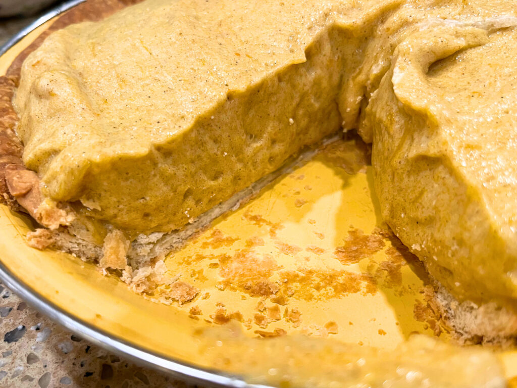 Looking at the inside of a pumpkin chiffon pie, from where a slice was removed.