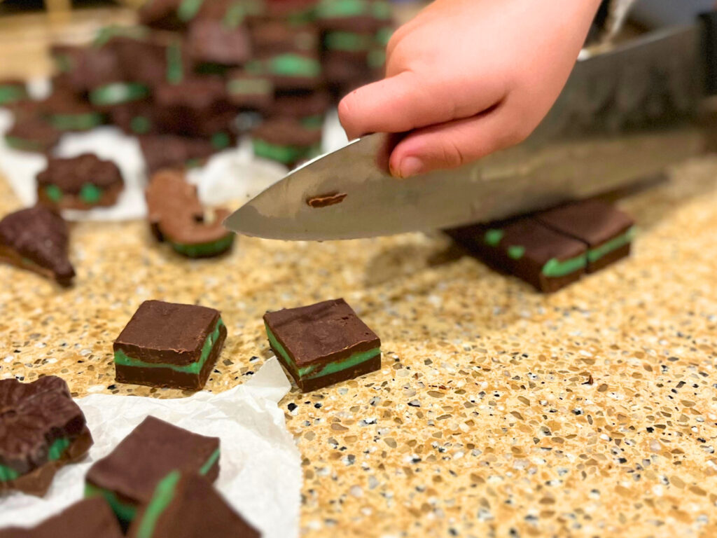 Cutting mint chocolate candies into bite sized pieces with a kitchen knife