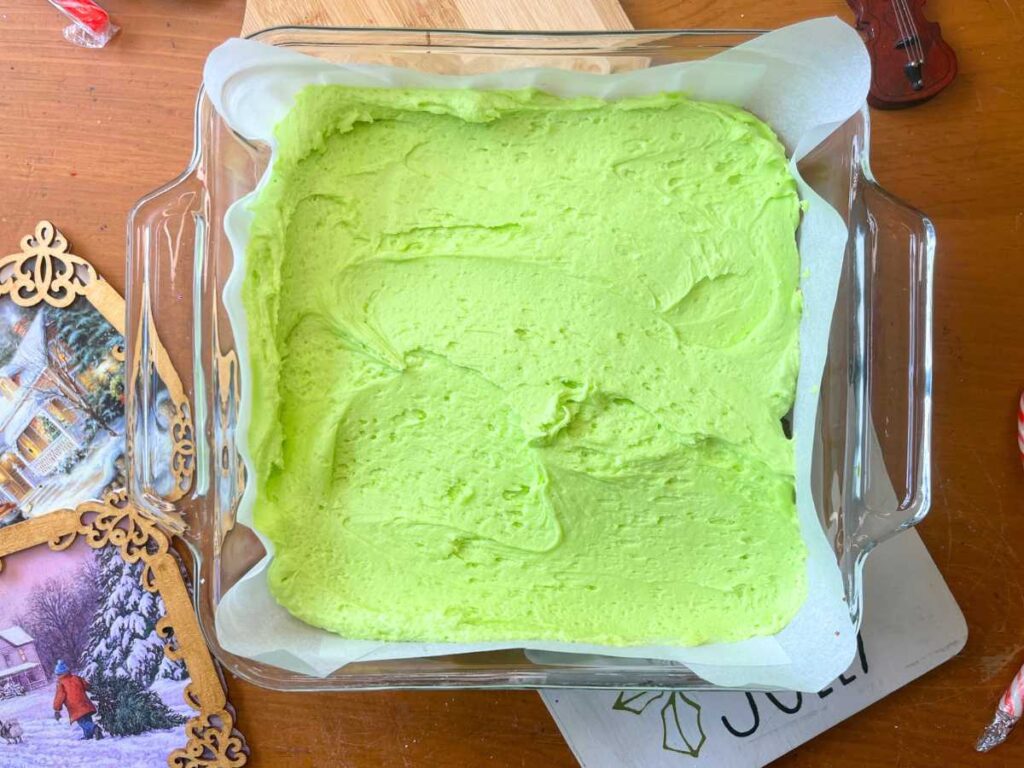 Mint icing spread into a square casserole dish.