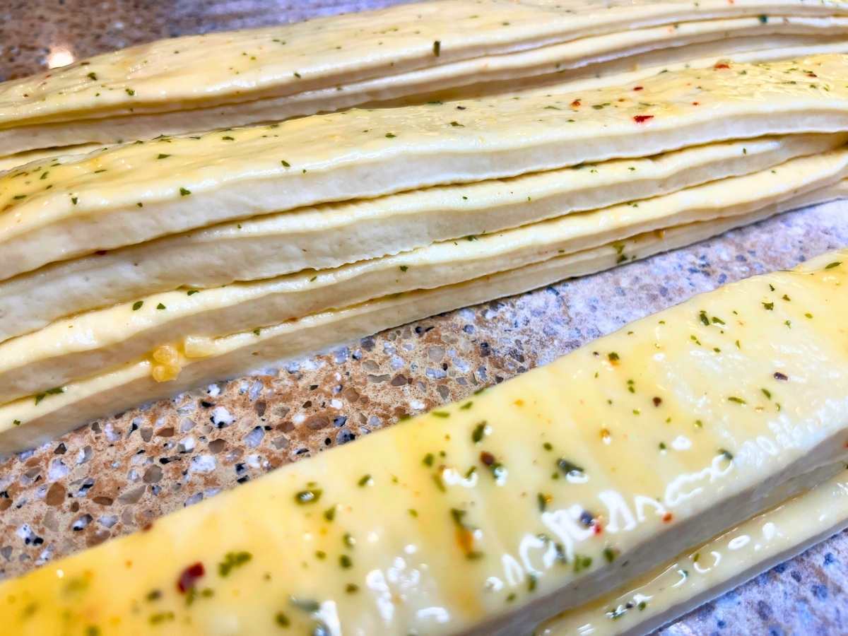 Stacked strips of dough brushed with garlic butter.