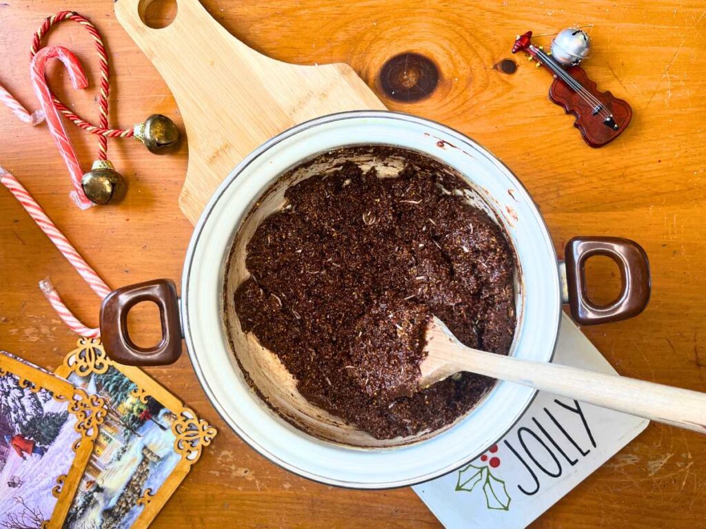 A white sauce pot with a thick chocolate mixture inside.