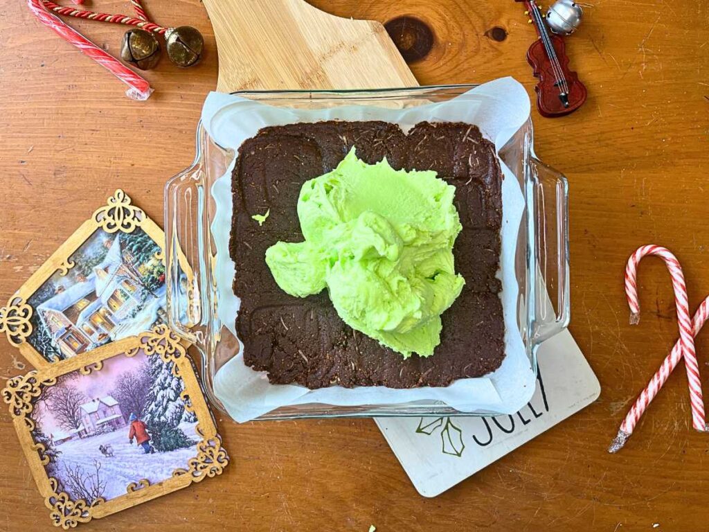 A square casserole dish with a chocolate base and green icing on top.