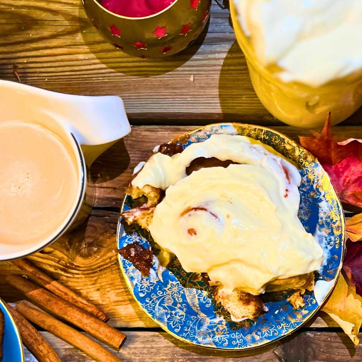 A cinnamon roll with cream cheese icing on a blue plate.