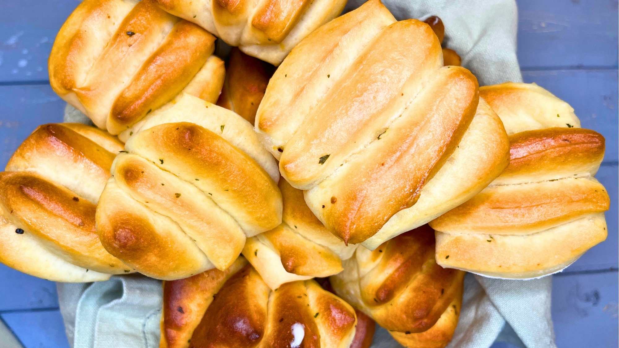 An overhead view of a basket of pull apart dinner rolls.