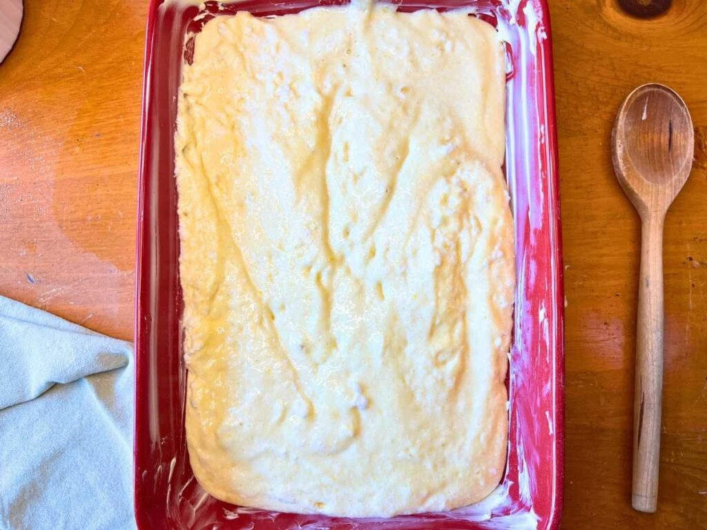 cake batter in a red casserole dish.