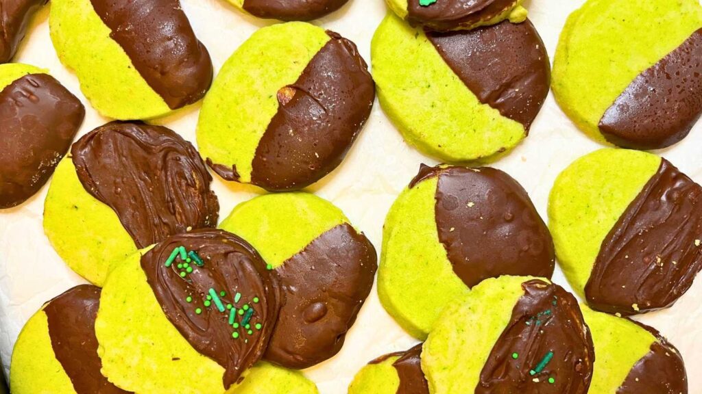 A batch of mint shortbread cookies that are dipped in chocolate.