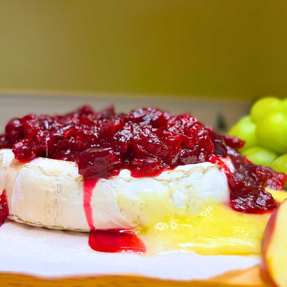 A wheel of Brie covered in cranberry sauce.