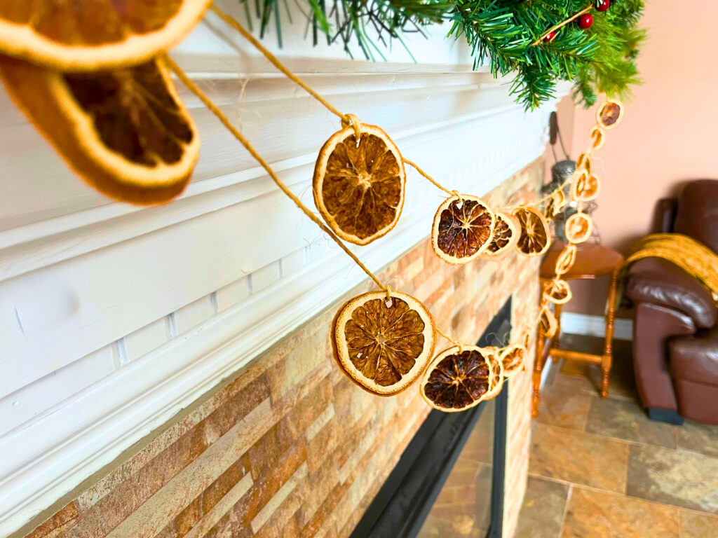Orange slice garland hanging from a mantle of a fireplace.