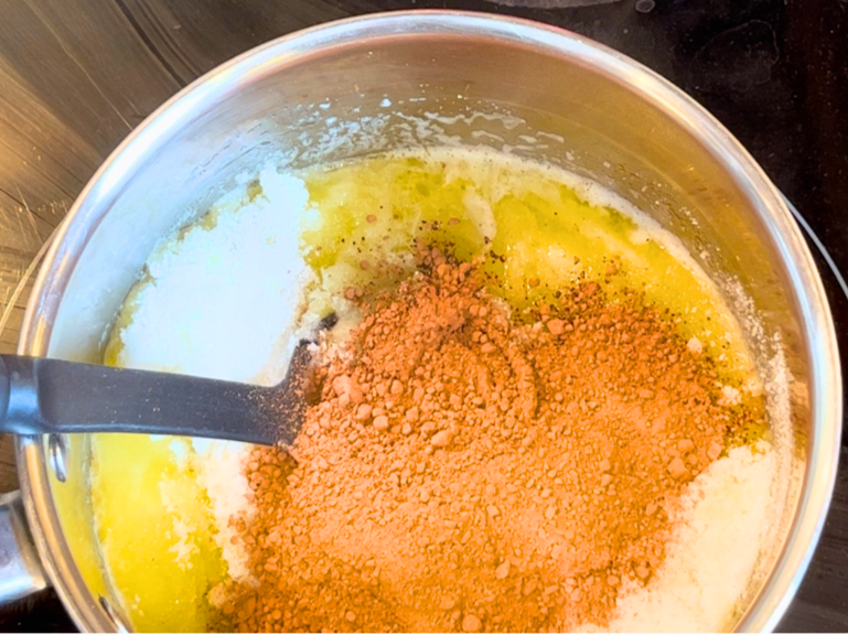A sauce pot with melted butter, sugar and cocoa powder.