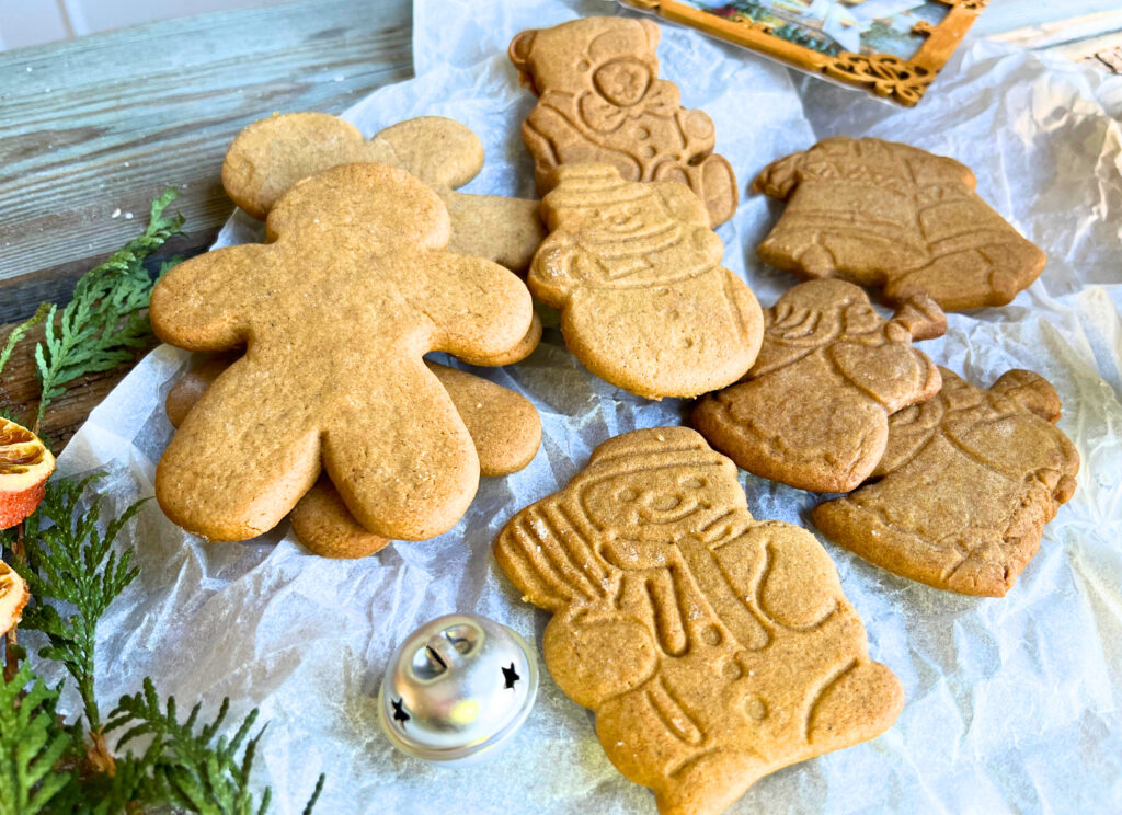 Gingerbread cookie cut-outs on a piece of parchment paper.