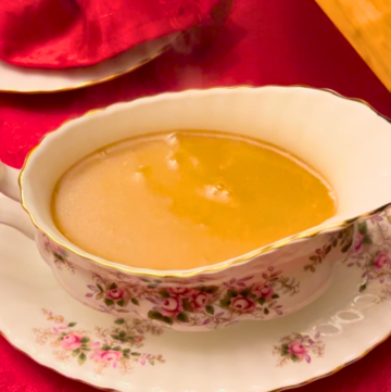 A white and pink floral gravy boat with sweet and salty gravy inside
