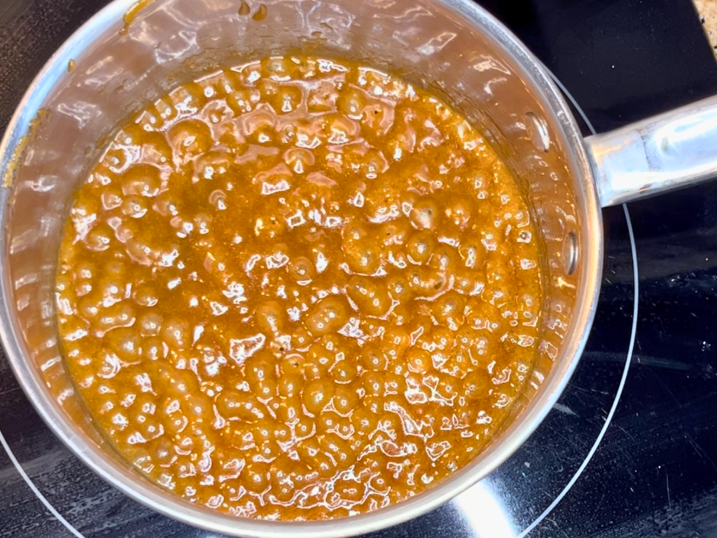 A sauce pot with boiling butter and brown sugar.