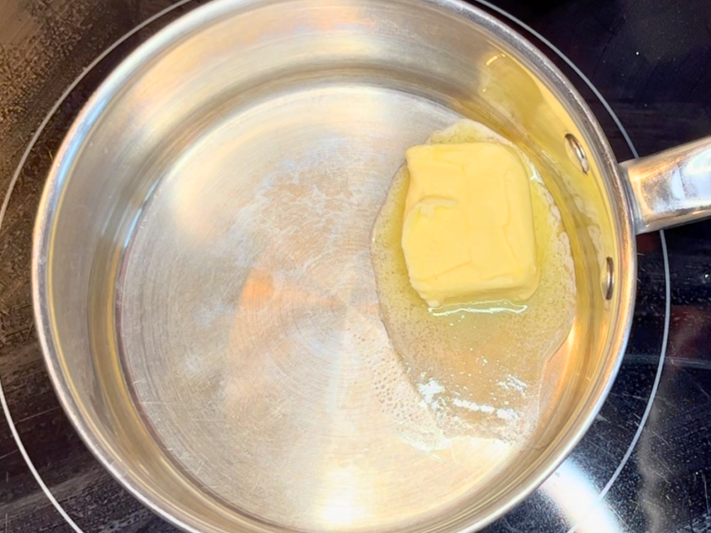 A sauce pot with melting butter inside.