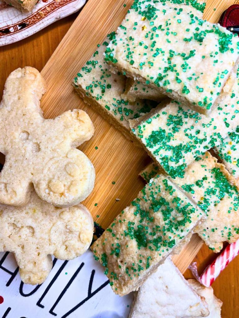 Shortbread cookies on a wooden serving tray. Some are dusted in green sanding sugar.