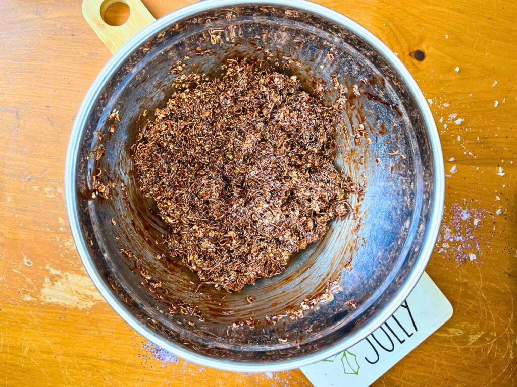 A metal bowl with an oat, chocolate, and coconut mixture.