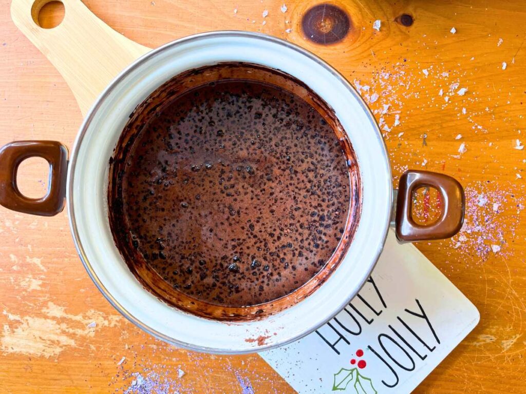 A sauce pot with a melted chocolate mixture inside.