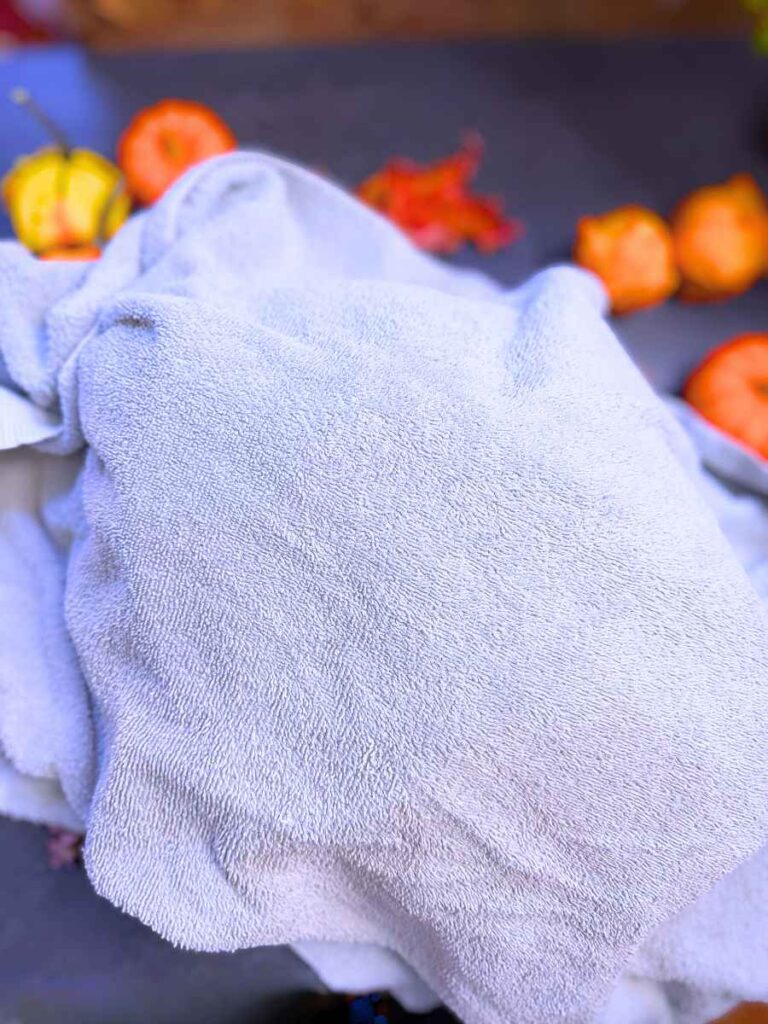 A roasting pan covered in a towel.