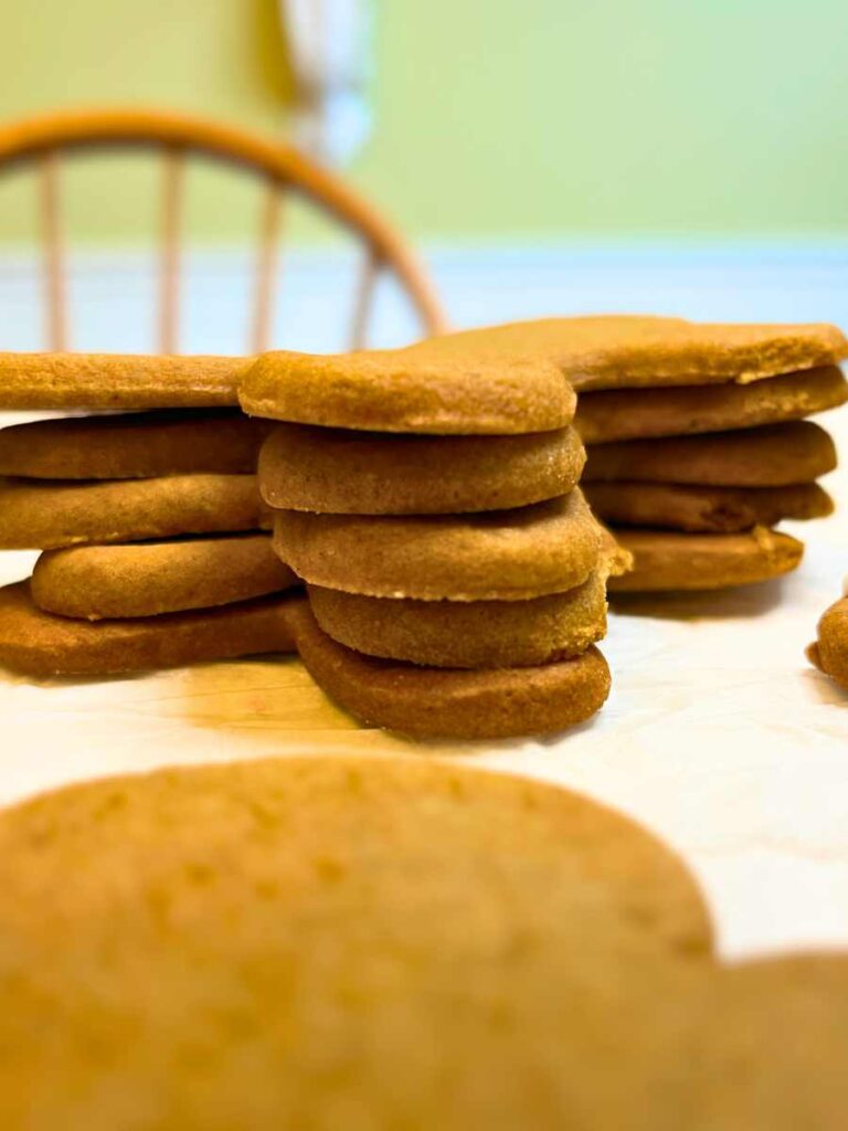 A stack of baked gingerbread men on a piece of parchment paper.