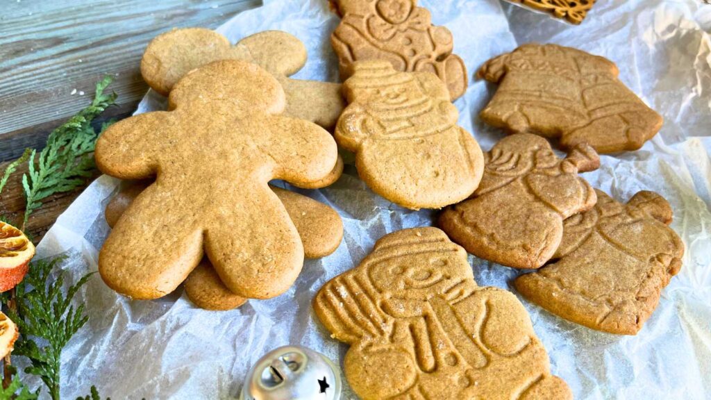 Some cut out gingerbread cookies on a piece of parchment paper.