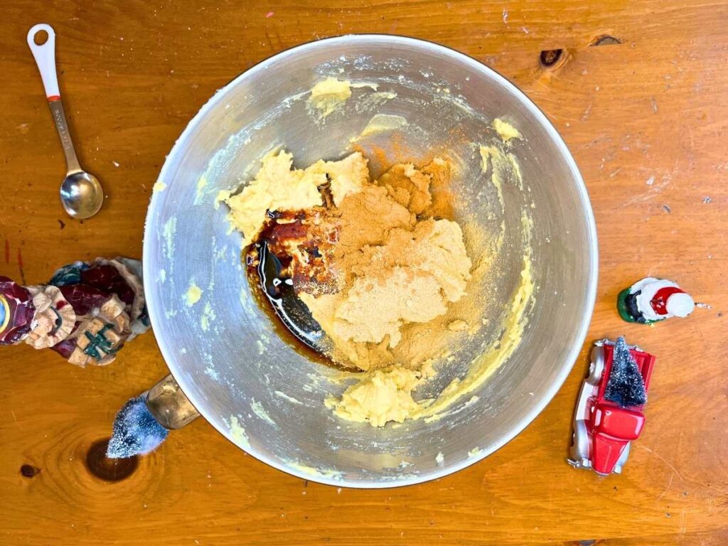 Softened butter with spices and molasses in a metal bowl.