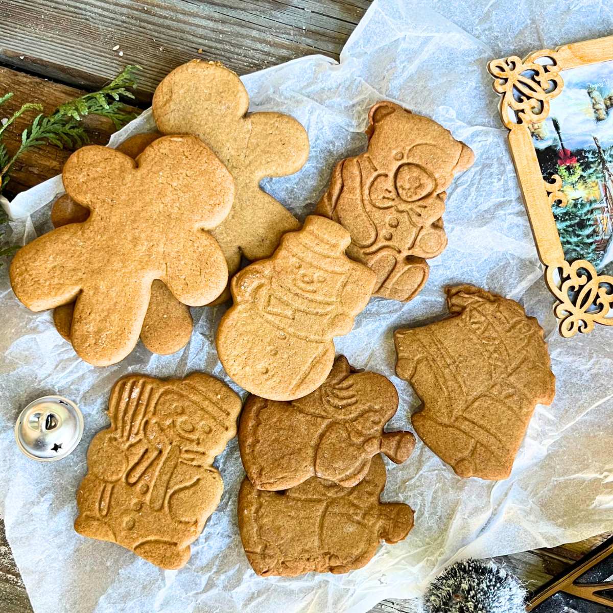 A group of cut out gingerbread cookies on a piece of parchment paper.