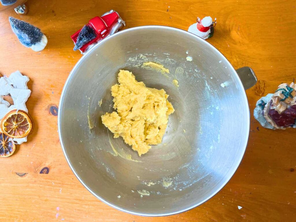 A metal bowl with creamed butter and sugar inside.