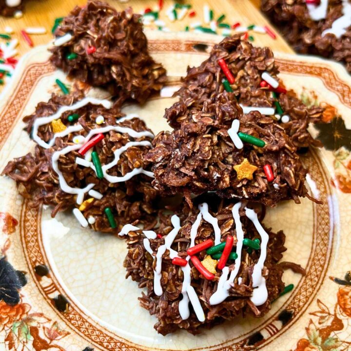 A brown floral plate with no back haystack cookies. Some are decorated with icing and sprinkles.