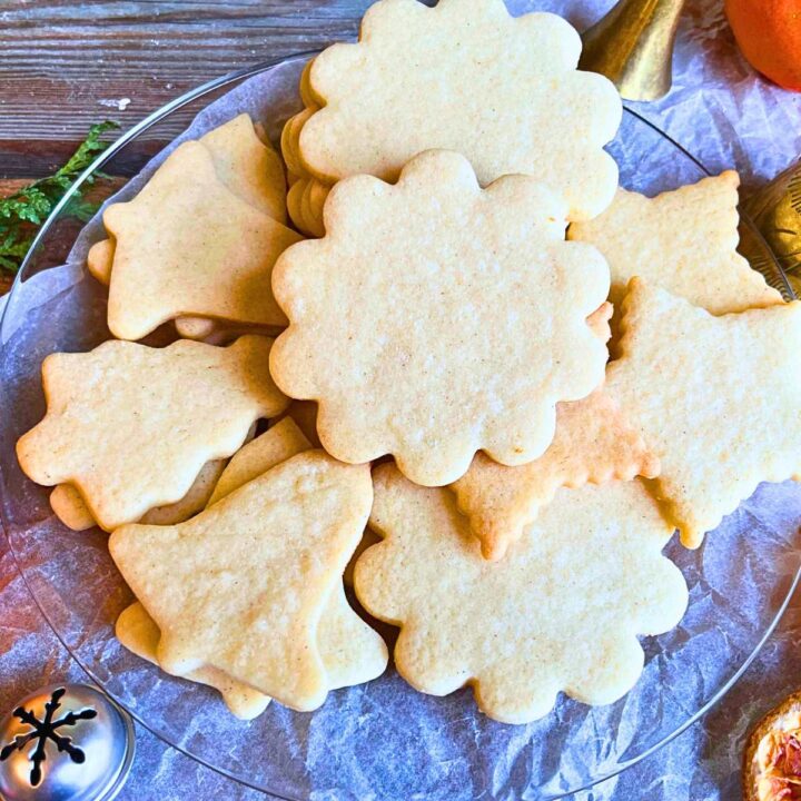 A plate full of cut out sugar cookies.