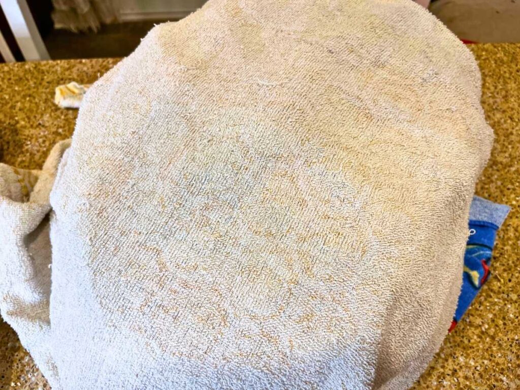 A roasting pan covered with a towel.