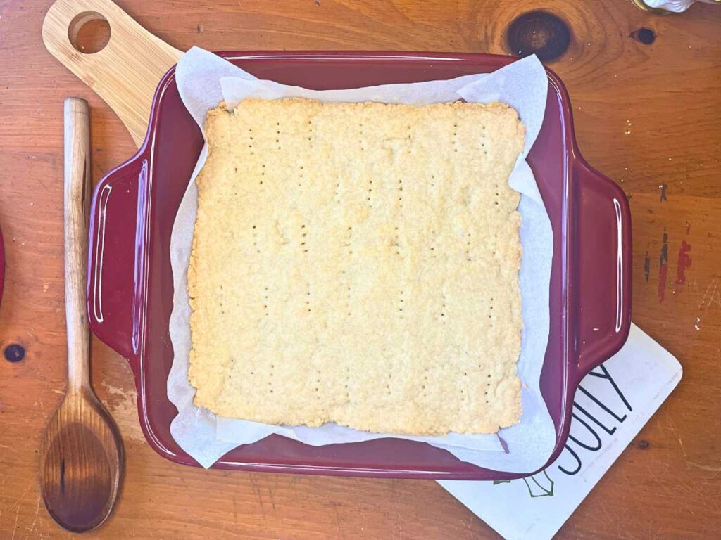 Baked shortbread in a red casserole dish.