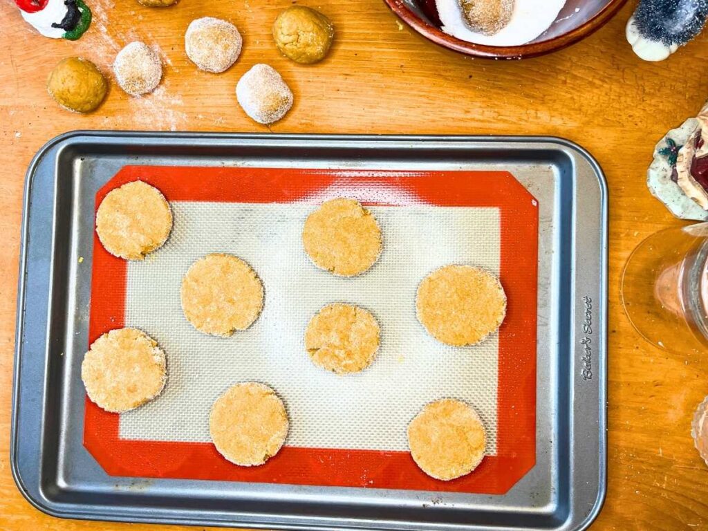 Unbaked gingerbread cookies on a lined cookie sheet.