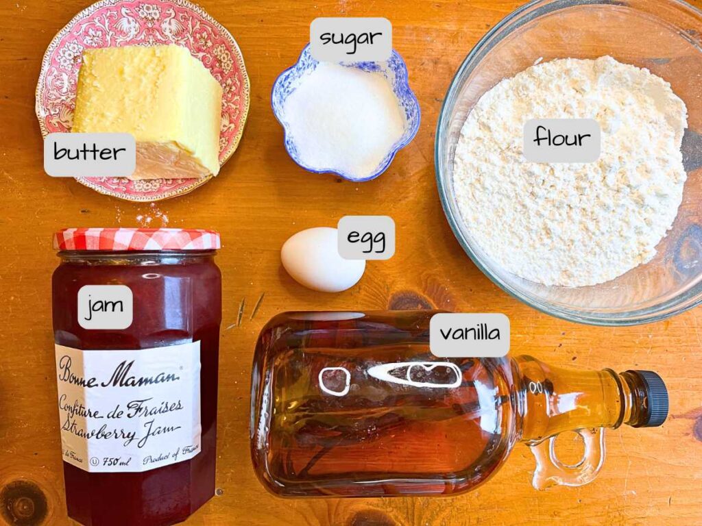 A collection of ingredients on a wooden table. They are labeled.