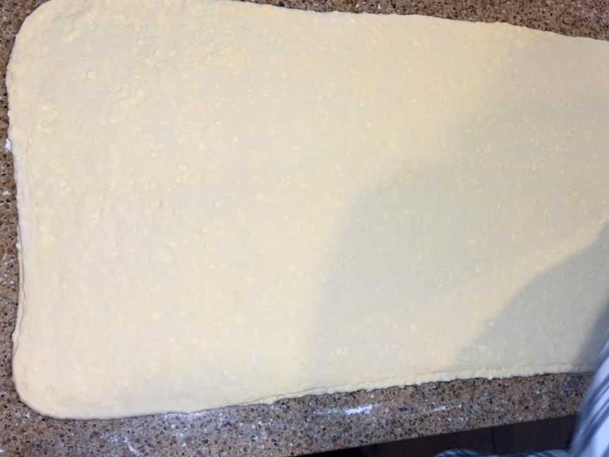 A long rolled out rectangle of puff pastry dough