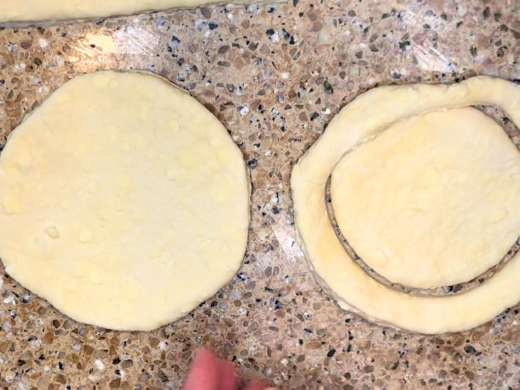 Puff pastry dough being cut in circle shapes.