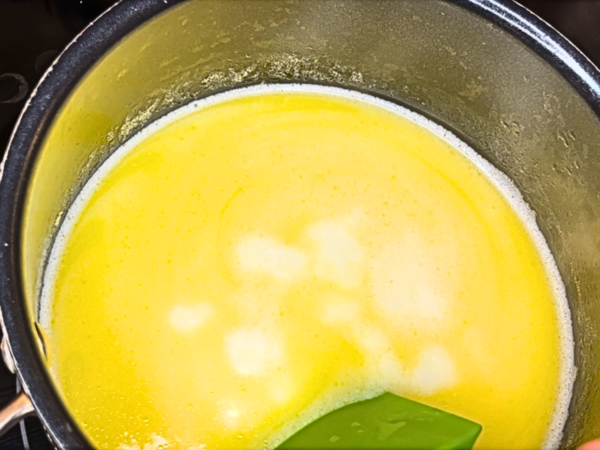 A milk and butter mixture simmering on the stove in a sauce pot.