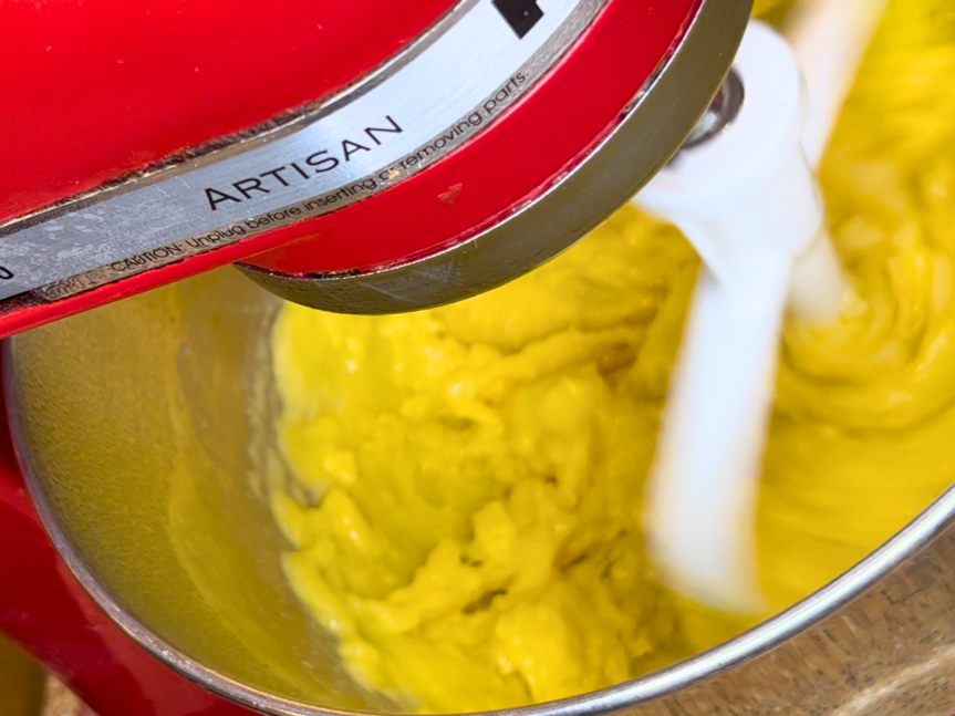 A stand mixer mixing pastry dough and eggs