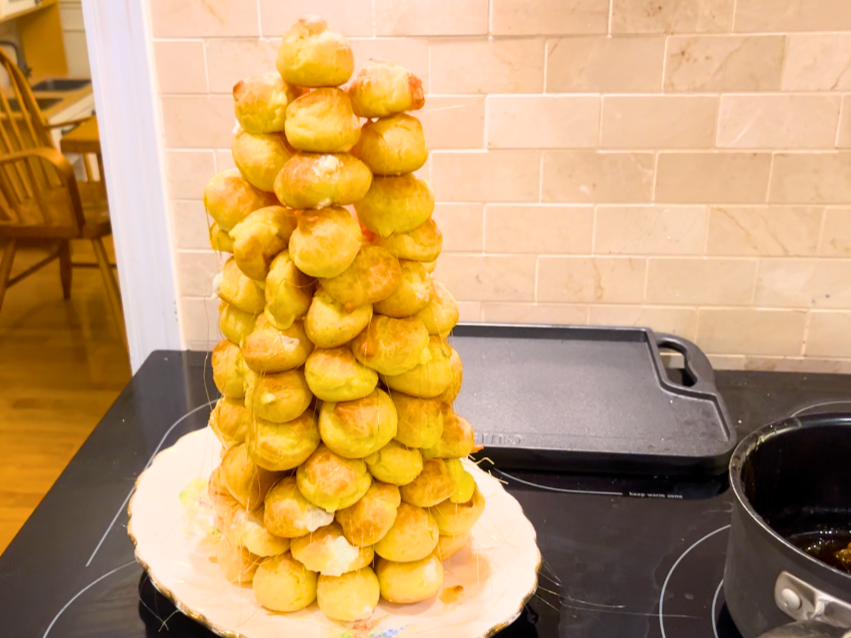 A tower of profiteroles on a decorative floral plate.