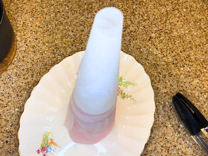 A parchment paper cone on a white floral plate.